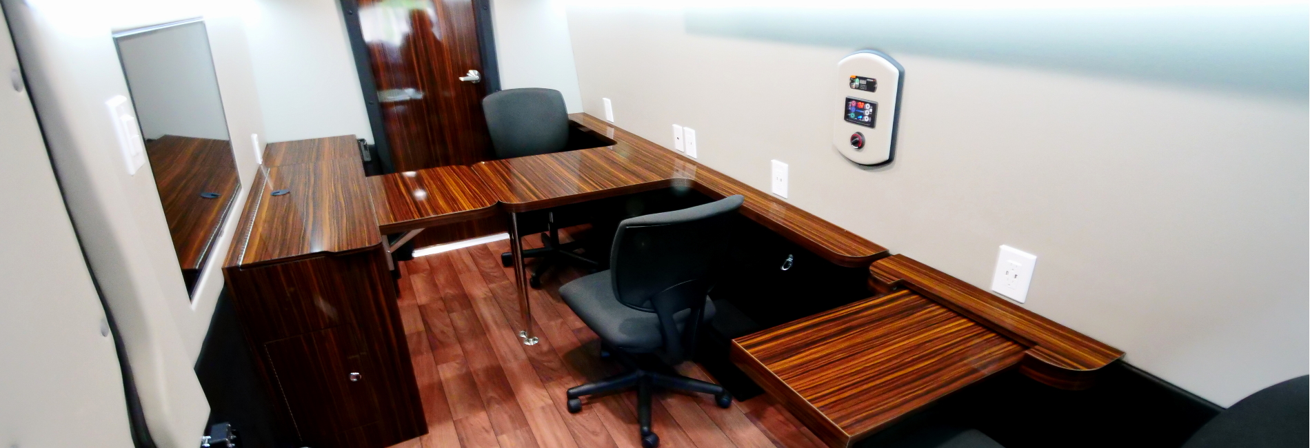 Featuring three rolling chairs, tables, overhead storage and cabinetry, TV display, wheelchair lift, and rear lavatory.